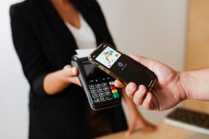 Kenyan SME owner using a mobile phone and a POS device